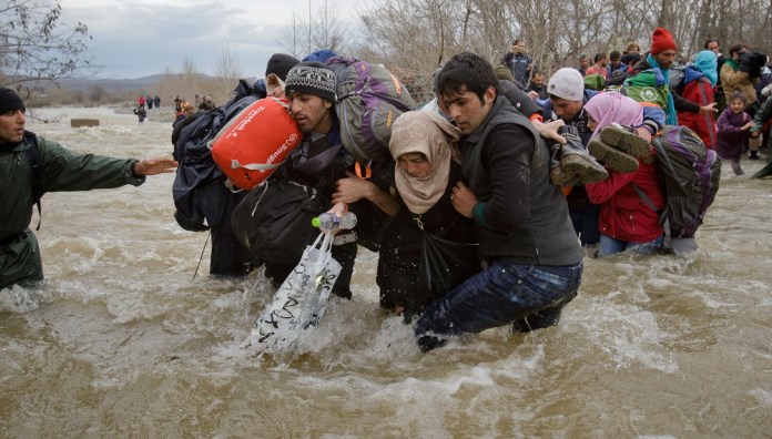 Migrants crossing river photo